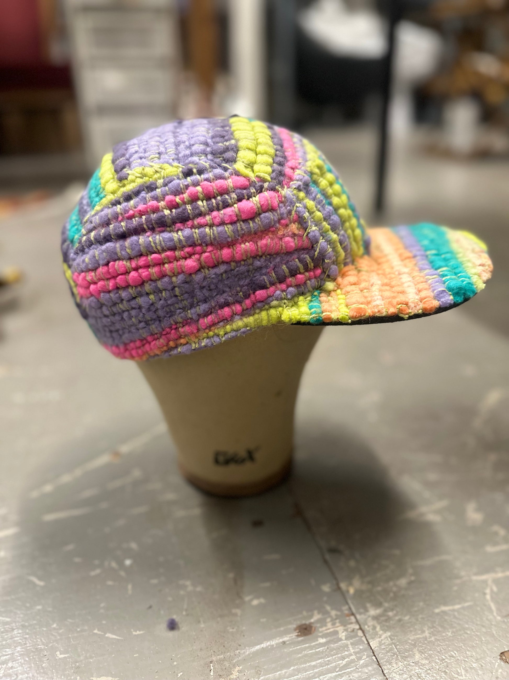 Woven 5 panel hat created using merino wool that is colorful. Neon pink, green, purple, orange and yellow. Product is handwoven and hand stitched. 